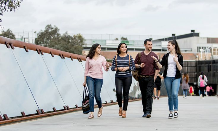 Four students smile while walking together at Burwood Campus