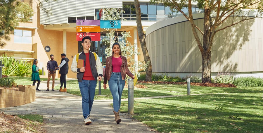 Two students walk outside Deakin Waurn Ponds campus. 