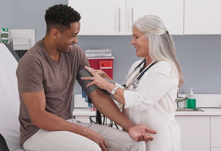 Nurse taking man's blood pressure