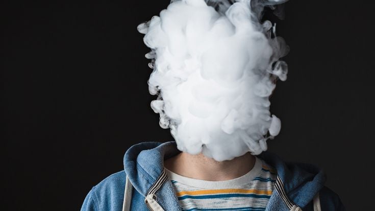 Person with face covered by smoke