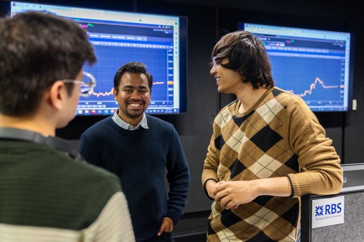 Three men chatting in computer room