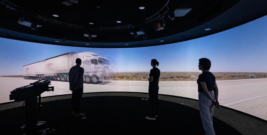 Students immersed in the 360-degree learning space with a truck driving down a road on screen