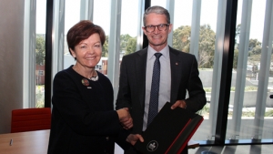 Deakin University Vice-Chancellor Professor Jane den Hollander presents Burnet Institute Director and CEO Professor Brendan Crabb AC with the MOU.