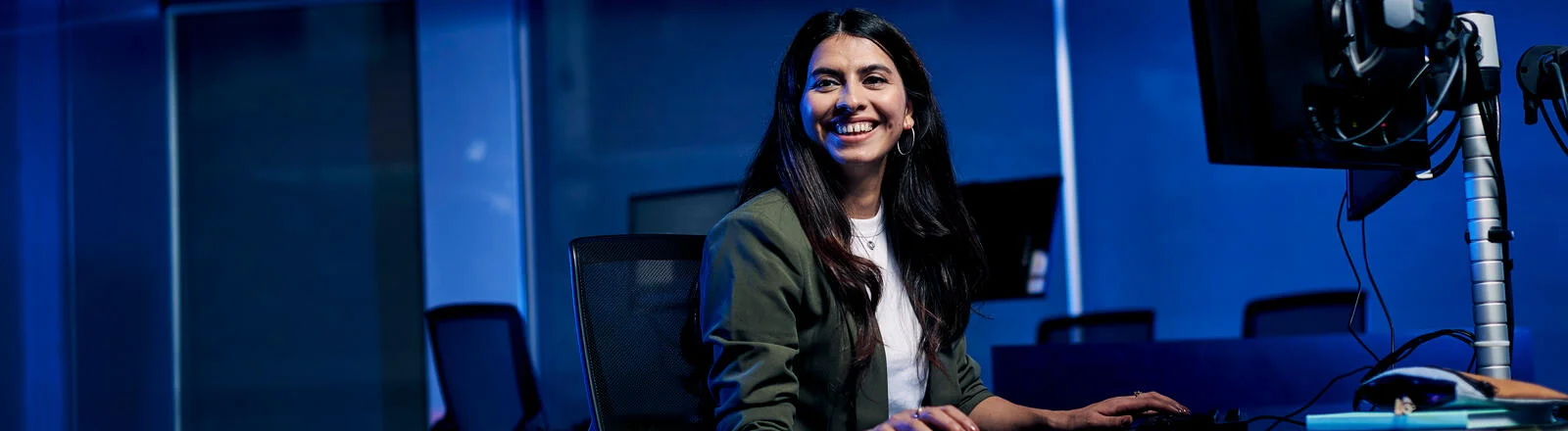 Deakin master of data science global student sits at table with computer.