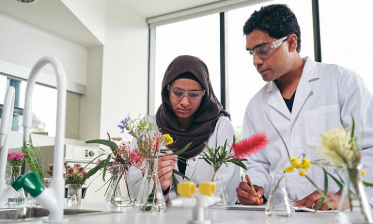 Two environmental science students in lab looking at flora