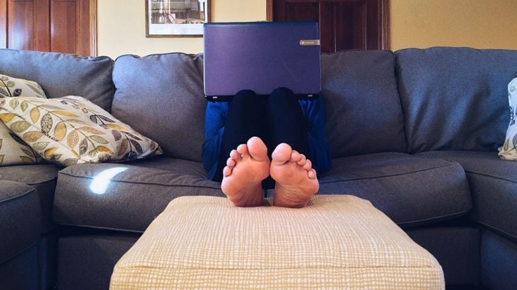Person on couch behind laptop