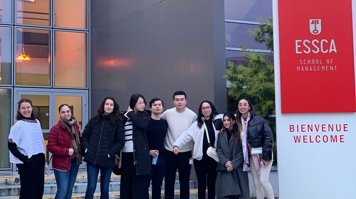 A group of students standing outside the ESSCA School of Management building