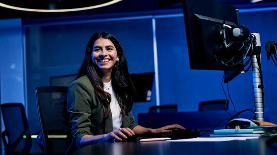 Deakin master of data science global student sits at table with computer.