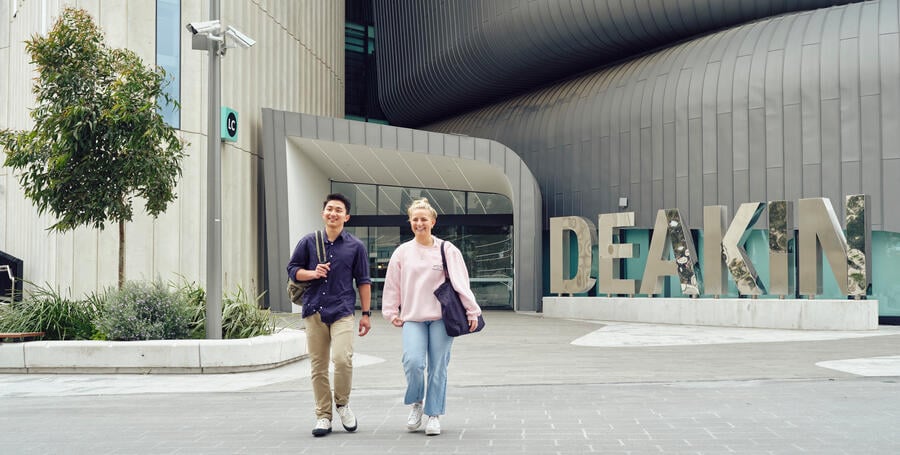 Two students walk outside the Deakin Burwood Campus. 