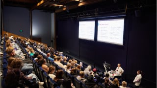 A group of people seated in a theatre at a Deakin Open Day information session. 