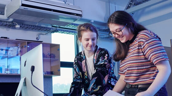 Two Deakin bachelor of creative arts students work in lab together.