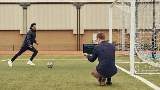 A Deakin bachelor of exercise student monitors a person kicking a soccer ball.