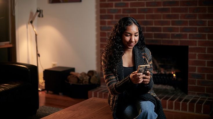 A student at home looking at their phone