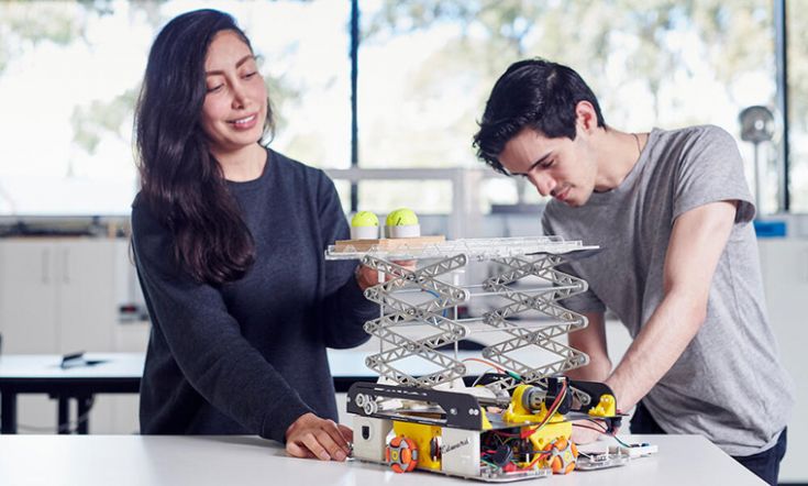 Two engineering students in a lab looking at a model.