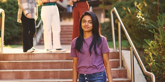 Student standing in front of stairs