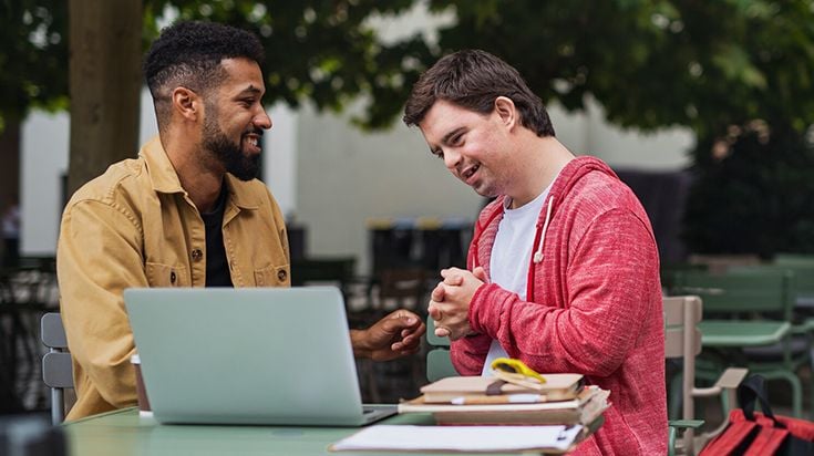 male student assisting person with disability