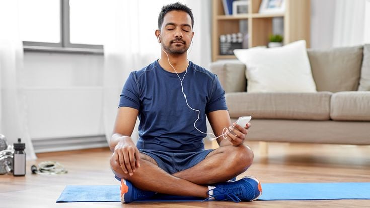 Male listening to music while sitting on floor.