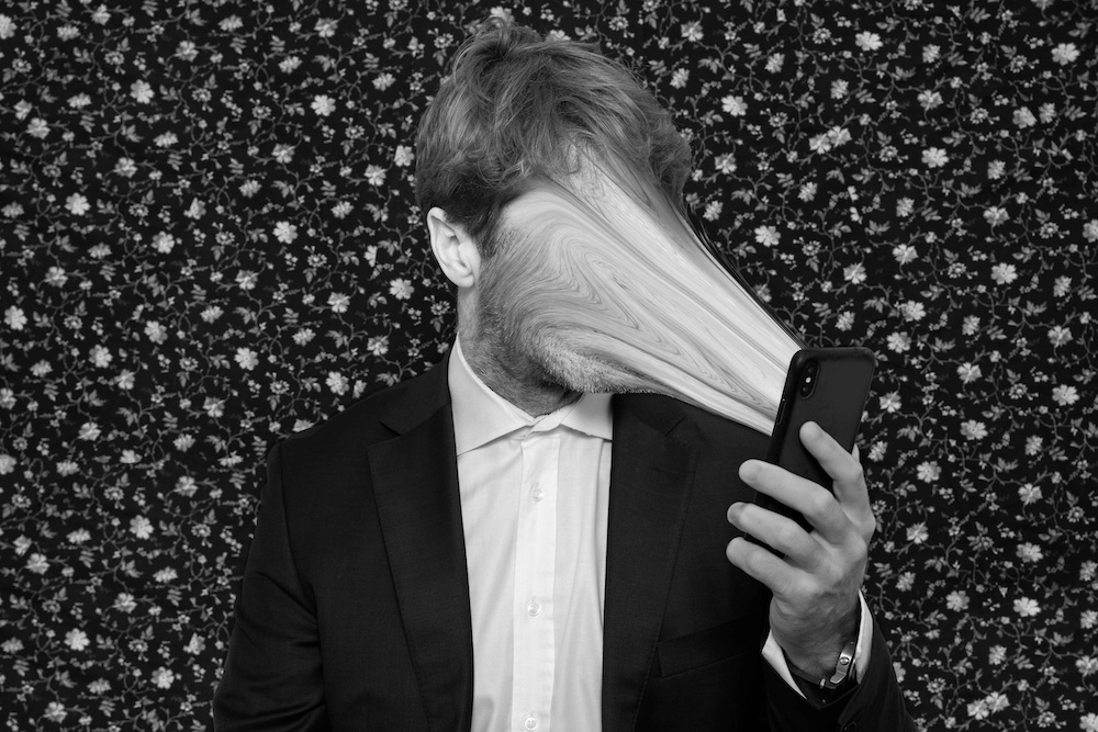 Black and white mans face pulled into phone screen
