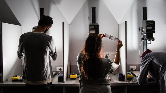 Three Deakin bachelor of creative arts honours students develop film in lab.