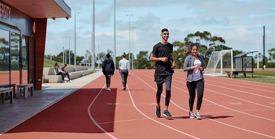 Two Deakin students on the running track at Deakin's Geelong Waurn Ponds Campus.