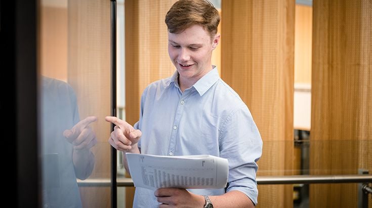 Student smiles while using a whiteboard at Burwood campus