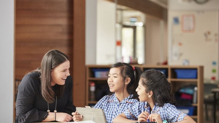 Student teacher in classroom with two children