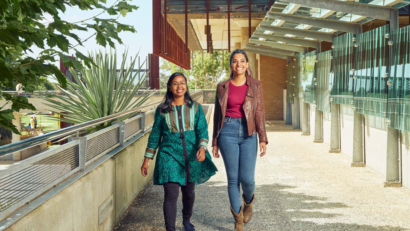 Two students walk outside at Deakin's Geelong Waurn Ponds Campus.