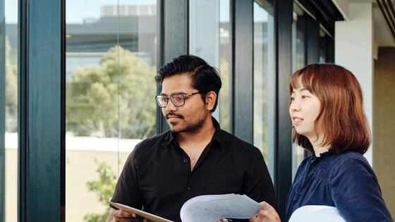 Two Deakin bachelor of construction management honours students stand together.