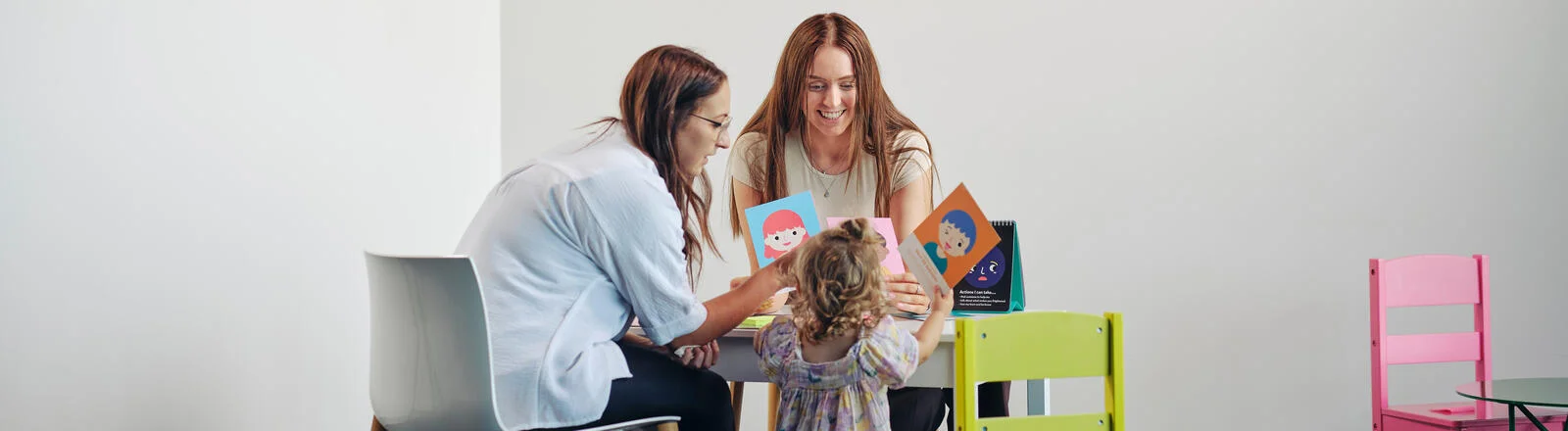 Two Deakin postgraduate therapeutic child play students interact with a child.