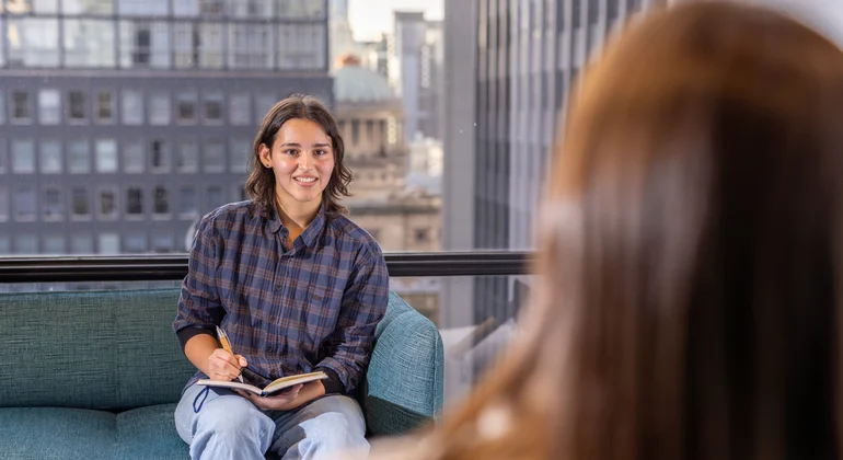 A law student taking notes in a client interview.