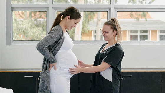 Deakin graduate diploma of midwifery student nurse performs check on pregnant woman in a clinical setting.