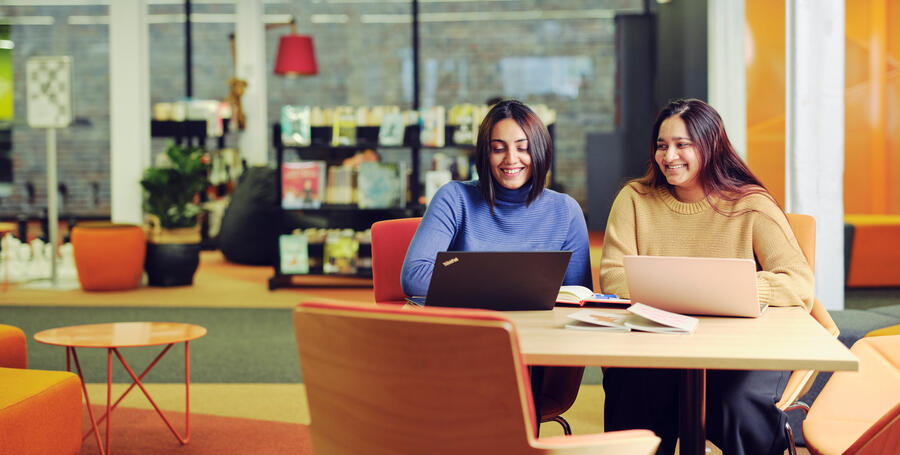 Two students sit together at Deakin Melbourne Burwood Campus.