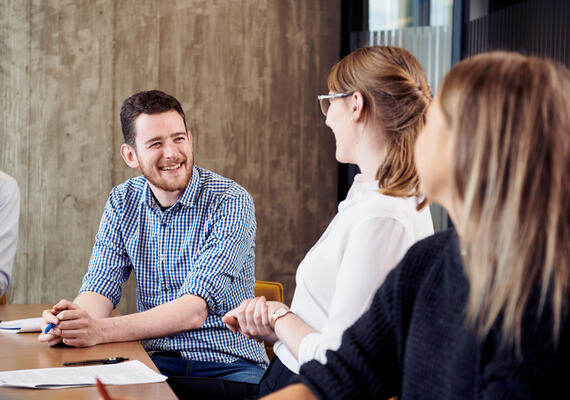 Three Deakin psychology students sit at a table discussing