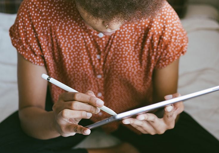 Student writing on tablet