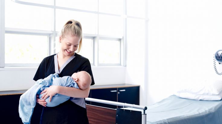 Nursing student holding a baby