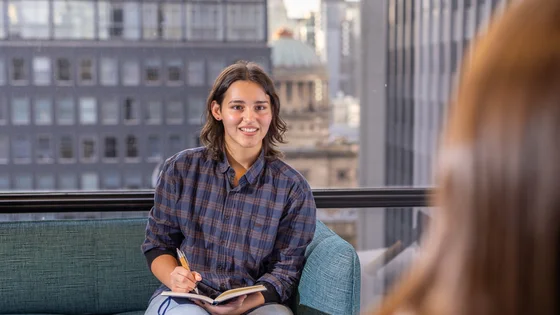 A law student taking notes in a client interview.