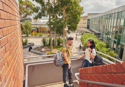 Two Deakins students stand outside Student Central on the Deakin Burwood Campus.