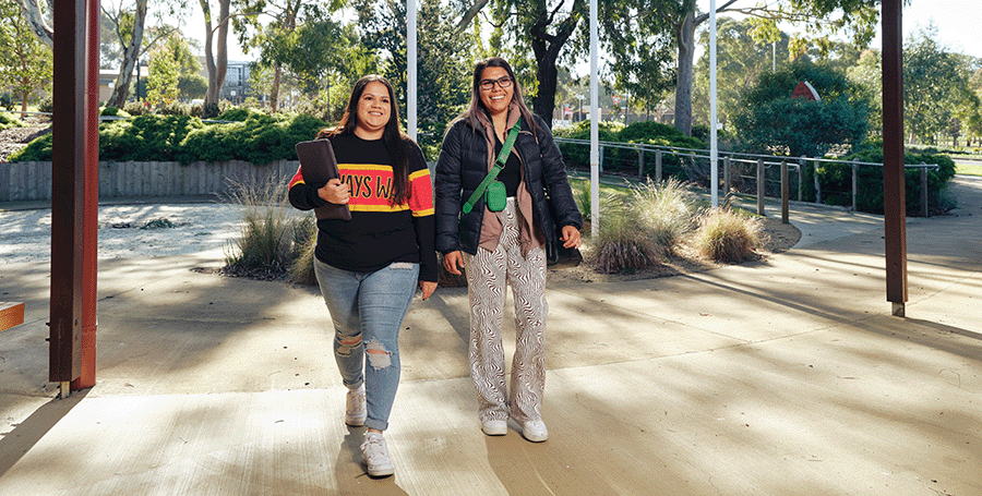 Two Deakin students walking in the Waurn Ponds Campus building.