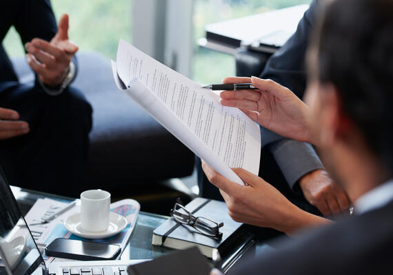 A group of people hold policy documents in hand