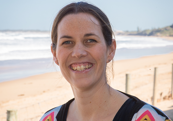 Deakin marine science student Prue Francis smiling on a beach.