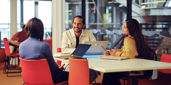 Three Deakin students study in the library.