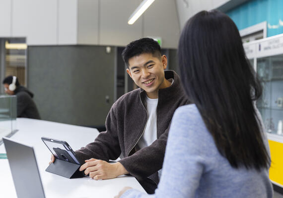 Student smiling and using a tablet