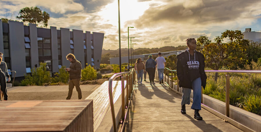 A Deakin Res student walking on a Warrnambool campus walkway