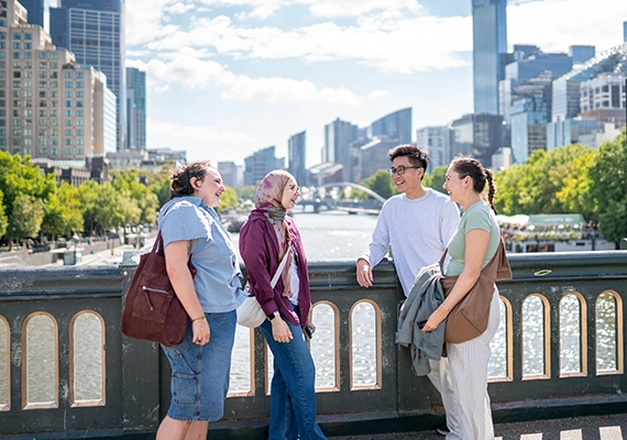 Four summer school students standing on a bridge in Melbourne city.