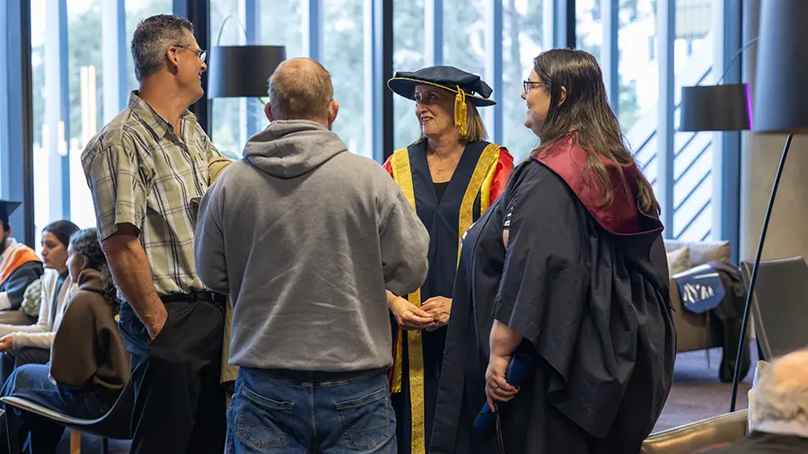 Graduands and guests talking with Chancellor Claire Higgins.