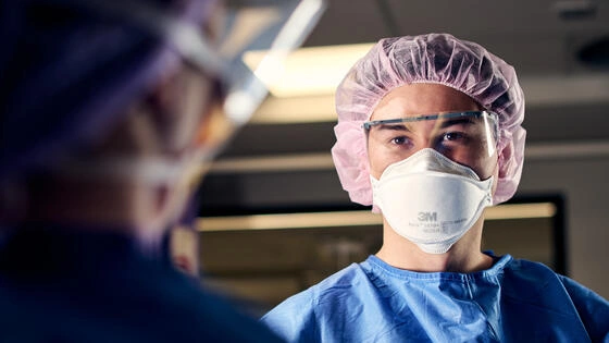 Deakin graduate diploma of perianaesthesia nursing student looks at camera in operating theatre.