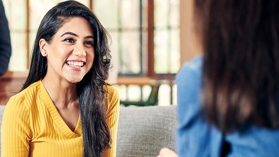 A group of students chatting together at home in a lounge room