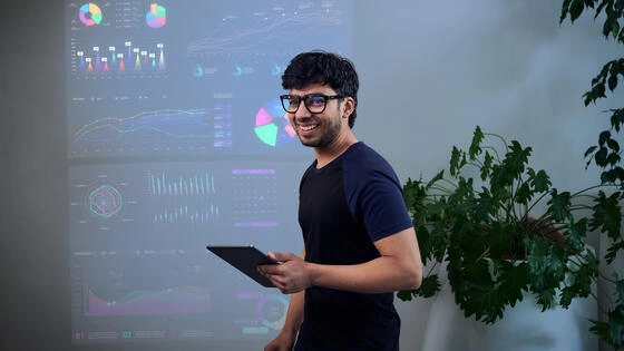 A Deakin master of business marketing student holds a tablet. 