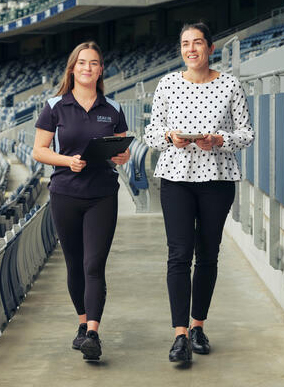 Two Deakin sport science students walk around a stadium while chatting about their work placement there.
