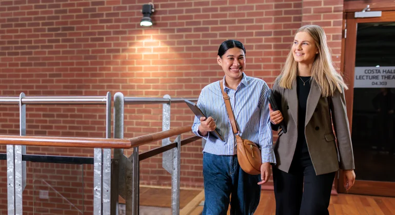 Two students walking to a lecture theatre.